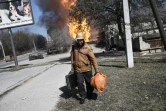 Un homme fuit son quartier après des tirs d'artillerie à Kharkiv, dans le nord-est de l'Ukraine, le 25 mars 2022 