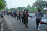 Des Indiens sans domicile fixe et qui ont pour la plupart perdu leur emploi font la queue lors d'une distribution de nourriture à New Delhi le 20 mai 2021