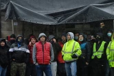 Des conducteurs de camions tentent de se protéger de la pluie à Douvres, dans le sud-est de l'Angleterre, où ils attendent l'autorisation d'embarquer pour la France le 23 décembre 2020
