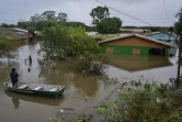 Un homme dans une barque se tient devant une maison inondée à Canoas, dans le sud du Brésil, le 13 mai 2024