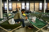 Un migrant assis sur un lit de camp dans un refuge à San Antonio, le 29 juin 2022 au Texas