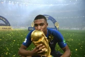 L'attaquant des Bleus Kylian Mbappé embrasse la Coupe du Monde, le 15 juillet 2018 à Moscou