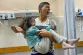 Un Palestinien transporte une fille blessée lors de frappes israéliennes à Khan Younès, à l'hôpital Nasser dans le sud de la bande de Gaza, le 3 juin 2025