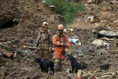 Des sauveteurs recherchent des survivants après des glissements de terrain et des inondations à Petropolis, le 16 février 2022 au Brésil