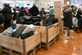Des acheteurs lors d'une "vente à l'aveugle" de colis non réclamés, où les boîtes de toutes tailles sont vendues au poids dans un centre commercial de Rome, le 17 janvier 2025 