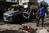 Des Palestiniens se rassemblent autour d'une épave de voiture après un bombardement israélien à Rafah, dans le sud de la bande de Gaza, le 8 janvier 2024