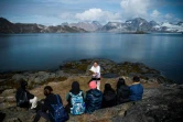 Un groupe de touristes accueilli à Kulusuk par un danseur traditionnel,l e 19 août 2019 au Groenland