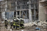 Des pompiers sont assis au milieu de débris dans la zone d'un institut de recherche, qui fait partie de l'Académie nationale des sciences d'Ukraine, après une frappe de drones qui a fait au moins un mort, dans le nord-ouest de Kiev, le 22 mars 2022