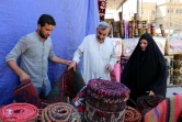 Une femme regarde des tapis traditionnels dans une échoppe du marché de Hilla, le 12 octobre 2017 en Irak