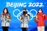 Les patineuses russes Alexandra Trusova (g), médaille d'argent, Anna Shcherbakov (c), médaille d'or, et japonaise Kaori Sakamoto (d), médaille de bronze, le 18 février 2022 aux Jeux olympiques de Pékin