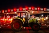 Des agriculteurs bloquent l'autoroute A10 avec des tracteurs, près des barrières de péage du Péage de Saint-Arnoult-en-Yvelines au sud-ouest de Paris, le 26 janvier 2024