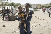 Un homme et son enfant ayant fui le Soudan, attendent à Metema, ville-frontière d'Ethiopie, le 4 mai 2023