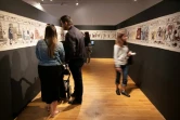 Des visiteurs admirent une immense tapisserie conçue pour rendre hommage à la série "Game of Thrones", le 5 juillet 2019 dans un musée de Belfast, en Irlande du Nord