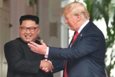 Le leader nord-coréen Kim Jong Un (g) et le président américain Donald Trump se serrent à la main, le 12 juin 2018 à l'hôtel Capella, à Singapour