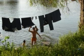 Des migrants honduriens se dirigeant vers les Etats-Unis font une pause au bord du fleuve Suchiate, le 18 janvier 2019 frontière naturelle entre le Guatemala et le Mexique
