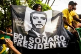 Des soutiens de Jair Bolsonaro défilent avec une affiche représentant leur candidat pour l'élection présidentielle brésilienne, le 29 septembre 2018 à Rio de Janeiro