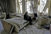 Un Syrien fume dans les ruines de sa maison en écoutant un disque sur un gramophone, à Alep, en Syrie,  le 9 mars 2017