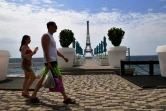 Un couple passe devant une copie de la Tour Eiffel sur une plade la Mer Noire à Yalta, principale station balnéaire sur la péninsule de la Crimée annexée, le 19 juin 2023