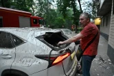 Un homme retrouve sa voiture endommagée après une série d'attaques russes contre la ville de Kharkiv, dans l'est de l'Ukraine, le 7 juin 2025