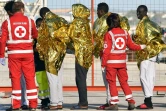 Des membres de la Croix-Rouge italienne prennent en charge des migrants débarqués du bateau de l'ONG allemande Sea Watch3, le 8 novembre 2017 à Pozzallo, en Sicile