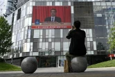 Un homme regarde la transmission en direct de la session inaugurale du parlement chinois à Pékin, le 22 mai 2020