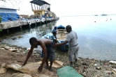 Des pêcheurs tirent un bateau pour le mettre à l'abri avant l'arrivée de l'ouragan Matthew à Kingston le 1er octobre 2016