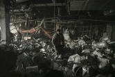 Un militaire ukrainien à l'intérieur du centre commercial après son bombardement, à Kiev le 21 mars 2022