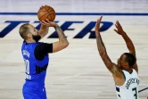 Evan Fournier prend un tir malgré la défense de George Hill de Milwaukee, lors du succès du Magic en playoffs NBA dans la bulle de Disney, le 18 août2020 