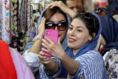 Une femme ajuste son voile et pose pour une photo avec une autre femme à Téhéran, le 5 septembre 2023