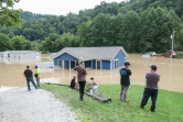 Une famille regarde sa maison inondée par des pluies torrentielles à Jackson, le 28 juillet 2022 dans le Kentucky