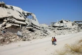 Des enfants marchent parmi les ruines dans un quartier rebelle de la ville de Deraa, le 17 septembre 2017