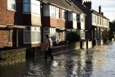 Une femme dans une rue inondée le 27 décembre 2015 à York