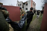 Des secouristes portent le corps d'une victime à Andriïvka, près de Kiev, le 11 avril 2022 en Ukraine
