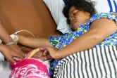 Dinar prend soin le 6 octobre 2018 de sa petite fille à laquelle elle a donné naissance sur un navire-hôpital après le terrible séisme suivi d'un tsunami qui a frappé Palu sur l'île des Célèbes en Indonésie 
