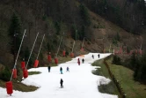 Des personnes s'entraînent à skier sur de la "neige stockée" fabriquée à partir de la neige tombée plus tôt dans les mois d'hiver, à la station de ski de La Bresse-Honeck (Vosges) le 30 décembre 2023