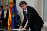 Le président catalan Carles Puigdemont signant un document sur l'indépendance catalane, au parlement régional, à Barcelone, le 10 octobre 2017