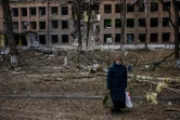 Une femme se tient devant un immeuble détruit après une attaque des forces russes dans la localité ukrainienne de Vasylkiv, près de Kiev, le 27 février 2022