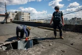 Des démineurs inspectent le toit d'un immeuble endommagé par un missile à Kharkiv, le 28 avril 2022  