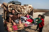 Un homme blessé est assis avec des enfants dans un camion fuyant les bombardements du régime syrien sur le sud de la province d'Idleb dans le nord-ouest de la Syrie, le 22 décembre 2019