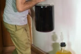 Un résident pakistanais transporte une bouteille de vin fait maison à son domicile à Islamabad, le 29 juin 2016 