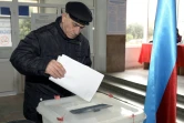 Un homme dépose son bulletin dans un bureau de vote de Bakou pour les élections législatives en Azerbaïdjan, le 9 février 2020