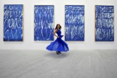 Une femme pose devant des tableaux du peintre américain Cy Twombly de la série "Untitled I-IX" au Louvre Abu Dhabi lors d'une visite organisée pour la presse le 6 novembre 2017