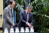 Le ministre de l'Intérieur Gérald Darmanin (à droite), allume une bougie portant le nom d'une victime de l'attentat de la rue des Rosiers à Paris, le 9 août 1982, en compagnie du président du Conseil représentatif des institutions juives de France (Crif) Yonathan Arfi, sur les lieux de l'attaque contre un restaurant juif lors d'une cérémonie marquant son 42e anniversaire vendredi
