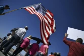 Des manifestants déploient le drapeau américain lors d'un rassemblement près d'un poste-frontière avec le Mexique, au Texas, pour protester contre les séparations de familles de migrants, le 21 juin 2018 