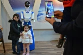 Des enfants posent pour une photo avec un robot-serveur dans le restaurant White Fox, à Mossoul, en Irak, le 17 novembre 2021