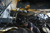 Un mécanicien agricole répare le moteur d'une moissonneuse-batteuse hors d'usage dans une ferme de Mykolaïv, dans le sud de l'Ukraine, le 11 juin 2022