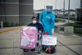 Guillermo Santos, rescapé du Covid-19, avec un membre dy personnel soignant, avant de quitter un centre de convalescence près de Lima le 28 août 2020