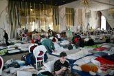 Des réfugiés ukrainiens dans une salle de bal d'hôtel transformée en abri de fortune pour les réfugiés ukrainiens à  Suceava, en Roumanie, le 15 mars 2022

