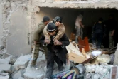 Un habitant d'un des quartiers assiégés d'Alep, extrait une vieille femme, des décombres d'une habitation visée par un bombardement, le 20 novembre