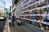 Des personnes passent devant des affiches des otages emmenés dans la bande de Gaza lors de l'attaque du Hamas le 7 octobre, à Tel-Aviv, le 11 août 2024